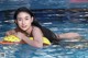 A woman in a swimming pool with an inflatable toy.