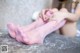 A woman in pink stockings is sitting on a table.